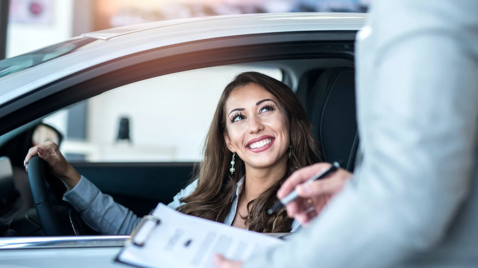 Jeune entrepreneuse qui vient d'être livrée de son véhicule professionnel peugeot en LLD sans bilan